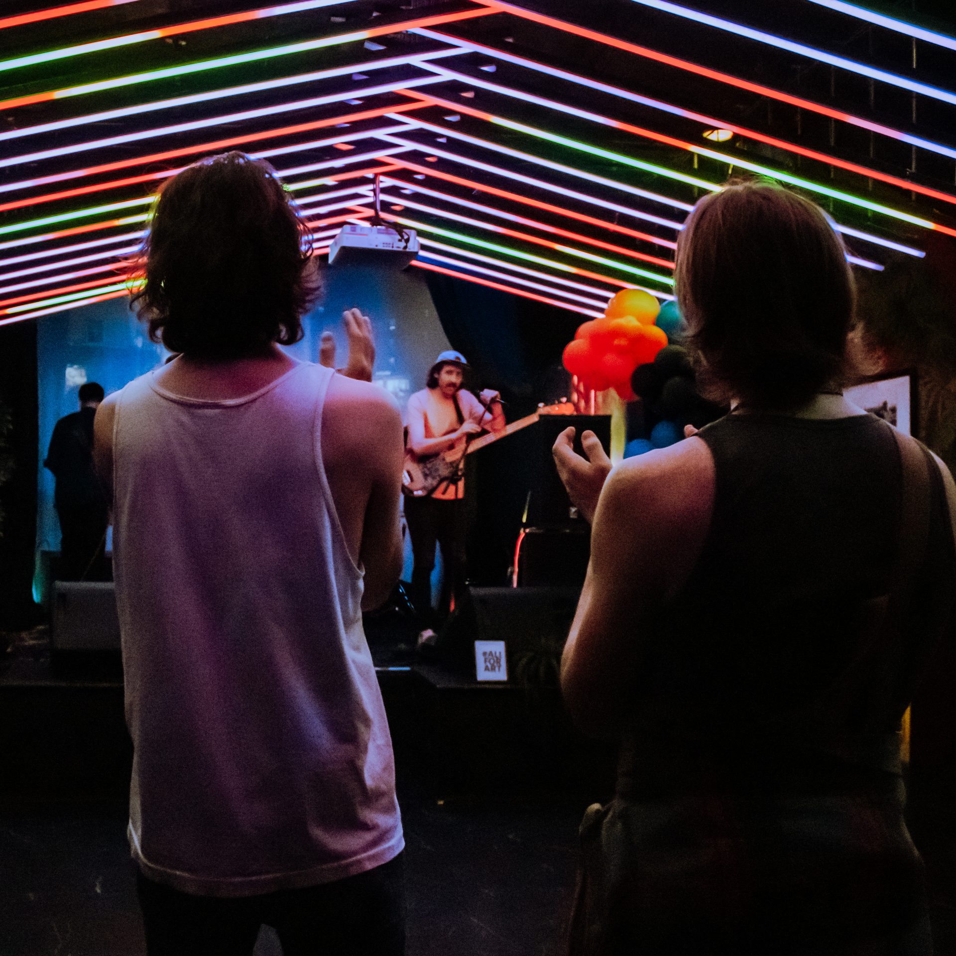 Wide stage shot of Caught Feelings performing live under warm stage lighting